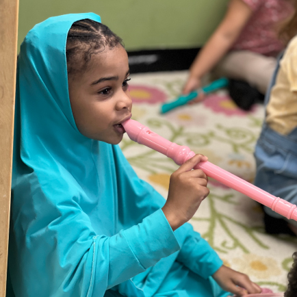 child playing a pink flute