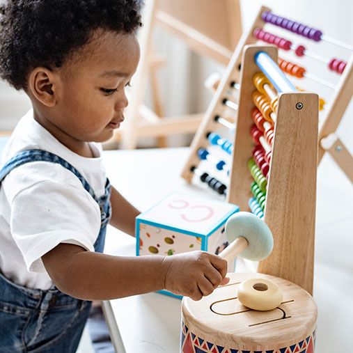 toddler playing with wooden toys